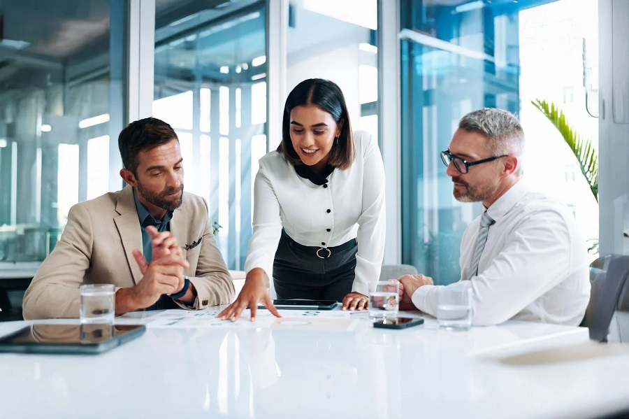 Effective Methods for Building a Resilient Business in Uncertain Times Three professionals around a conference table reviewing documents together